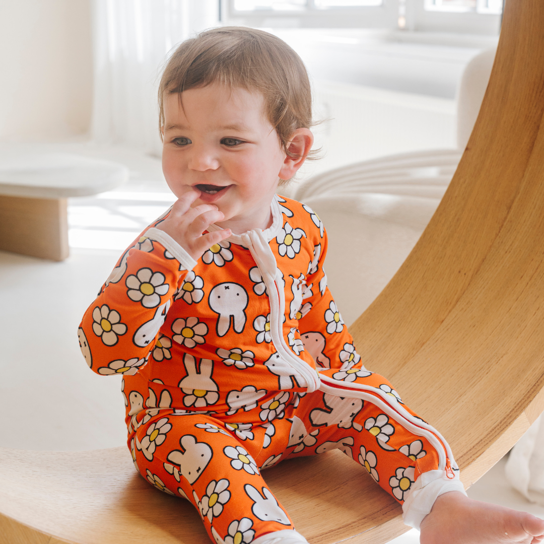 Baby wearing the ZIPSTER x Miffy Daisy Days bamboo babygrow